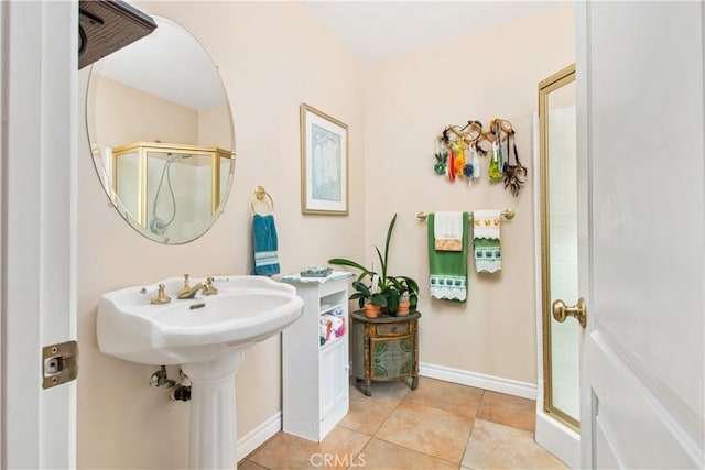 full bathroom featuring tile patterned flooring, baseboards, and a stall shower