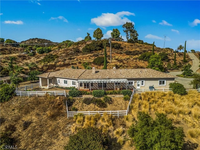 back of property featuring stucco siding, fence, and a tile roof
