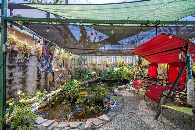 view of patio featuring a garden pond