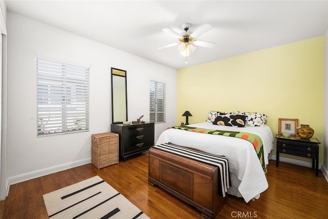 bedroom featuring ceiling fan, baseboards, and wood finished floors