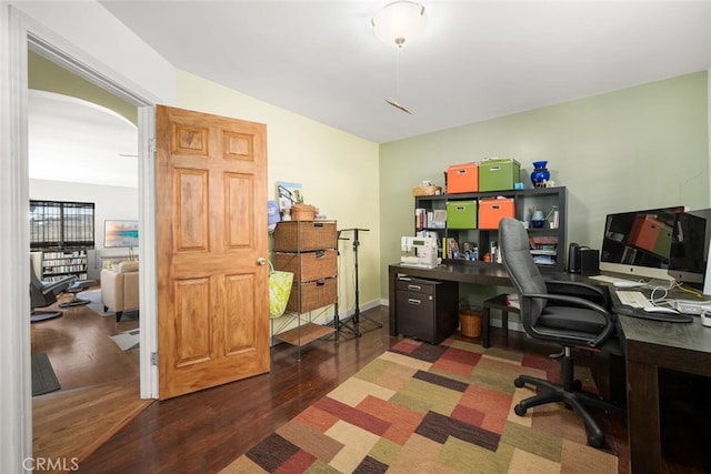 office space featuring arched walkways, vaulted ceiling, and wood finished floors