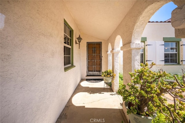 property entrance with a tile roof and stucco siding