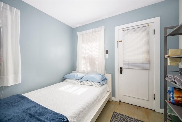 bedroom with baseboards and light wood finished floors