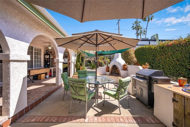 view of patio featuring outdoor dining space, grilling area, an outdoor fireplace, and area for grilling