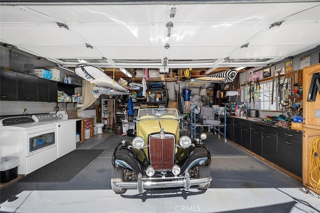 garage with washing machine and clothes dryer and a workshop area