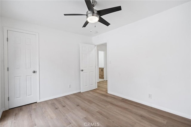 unfurnished bedroom featuring ceiling fan, baseboards, and wood finished floors