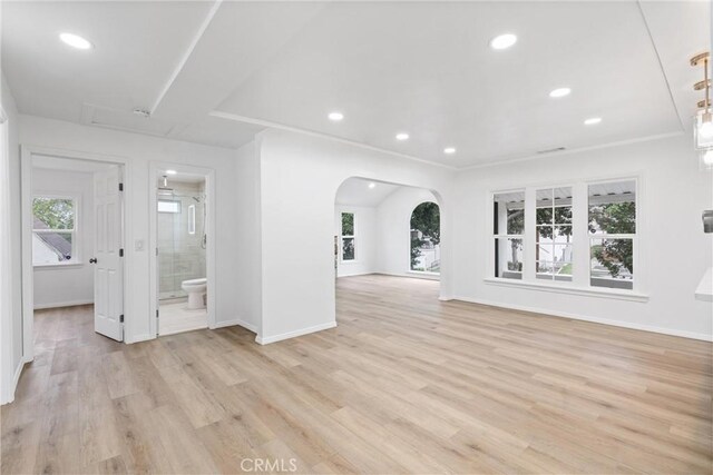 6010 S Verdun Ave, Los Angeles, CA 90043 - unfurnished living room with arched walkways, baseboards, recessed lighting, and light wood-style flooring