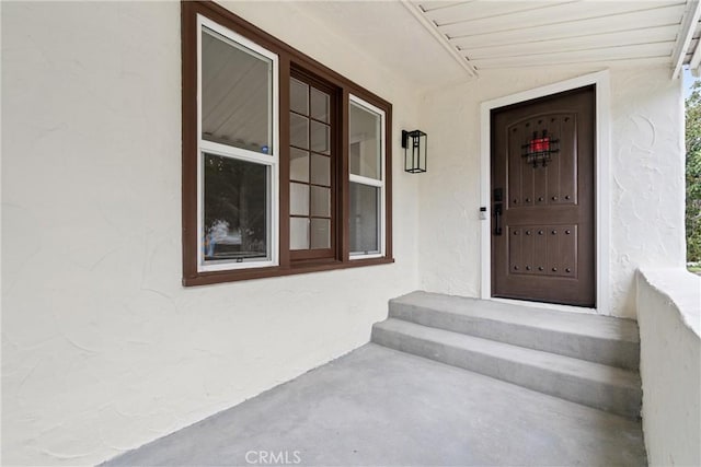 view of exterior entry featuring stucco siding