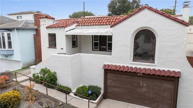 6010 S Verdun Ave, Los Angeles, CA 90043 - mediterranean / spanish-style house featuring a tile roof, an attached garage, stucco siding, and a chimney