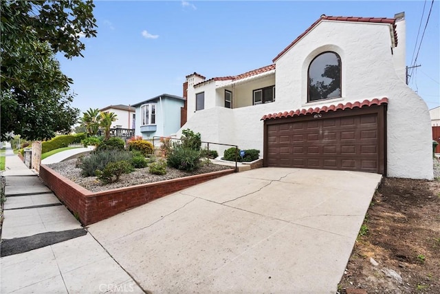 6010 S Verdun Ave, Los Angeles, CA 90043 - mediterranean / spanish-style home featuring an attached garage, stucco siding, a tile roof, driveway, and a chimney