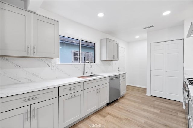 6010 S Verdun Ave, Los Angeles, CA 90043 - kitchen with stainless steel dishwasher, a sink, backsplash, light wood-style floors, and recessed lighting