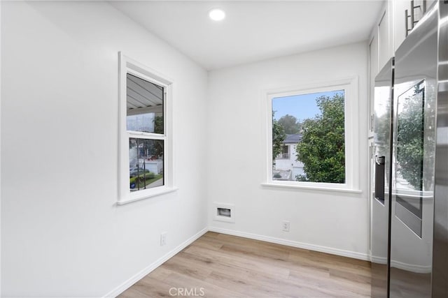 unfurnished room featuring light wood-type flooring, baseboards, and recessed lighting