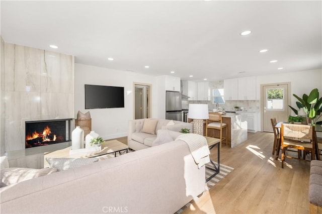 3748 Marber Ave, Long Beach, CA 90808 - living room with light wood-style flooring, a tiled fireplace, recessed lighting, and baseboards