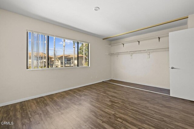unfurnished bedroom with a closet, baseboards, and wood finished floors