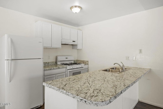 kitchen featuring white cabinets, a peninsula, white appliances, under cabinet range hood, and a sink