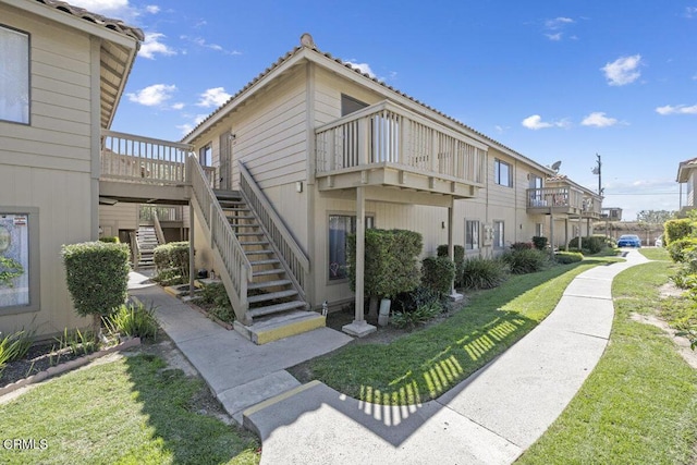 exterior space with stairs and a lawn