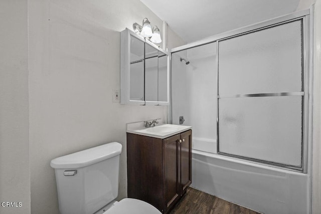 bathroom with combined bath / shower with glass door, wood finished floors, toilet, and vanity