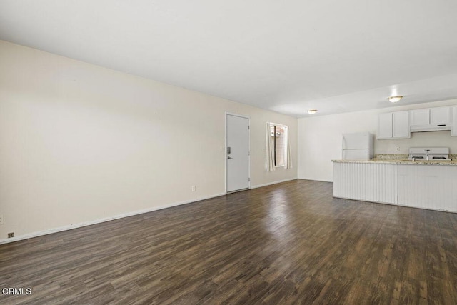 unfurnished living room featuring dark wood-type flooring and baseboards