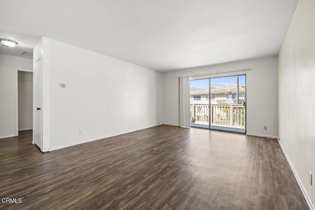 unfurnished room featuring baseboards and dark wood finished floors