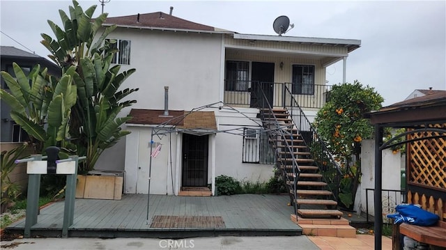 view of front of home featuring stucco siding and stairway