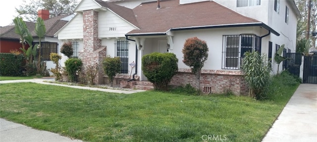 view of front facade with stucco siding and a front lawn
