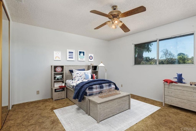 bedroom featuring carpet floors, ceiling fan, and a textured ceiling