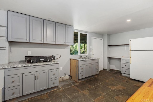 kitchen with open shelves, a sink, freestanding refrigerator, recessed lighting, and gray cabinetry