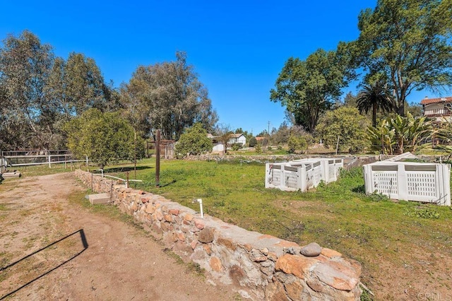 view of yard with fence and a vegetable garden