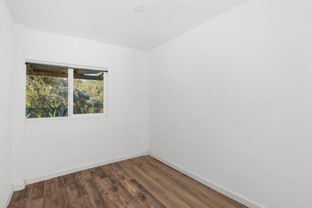 unfurnished room with baseboards and wood finished floors