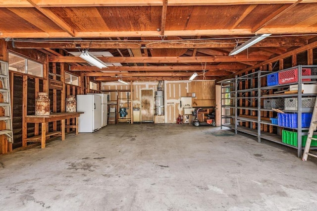 garage with strapped water heater and freestanding refrigerator