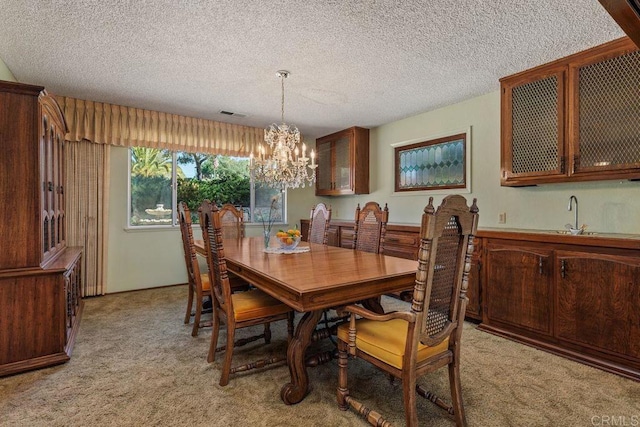 dining area with visible vents, a notable chandelier, light colored carpet, and a textured ceiling