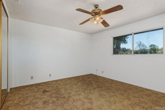 carpeted spare room featuring a textured ceiling and ceiling fan