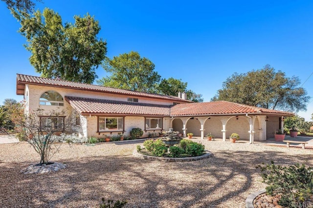 mediterranean / spanish-style house featuring stucco siding and a tile roof