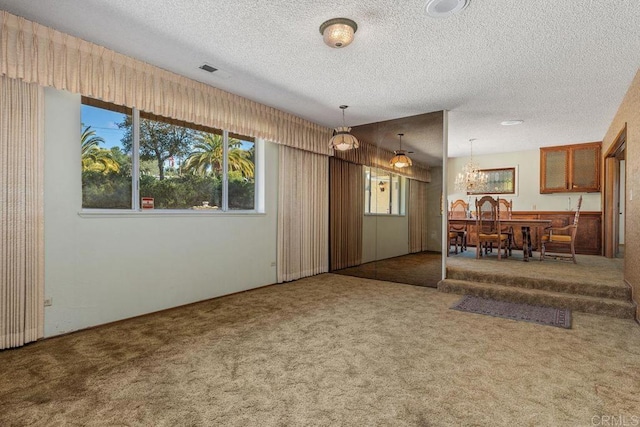 carpeted dining space featuring visible vents, a textured ceiling, and an inviting chandelier