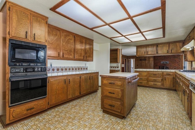 kitchen featuring brown cabinets and black appliances