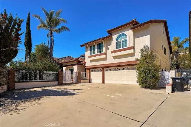 1135 Summitridge Dr, Diamond Bar, CA 91765 - mediterranean / spanish-style house featuring driveway, a gate, stucco siding, a tiled roof, and a garage