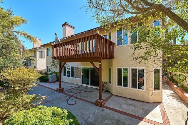 1135 Summitridge Dr, Diamond Bar, CA 91765 - back of property featuring stucco siding, a chimney, central AC unit, and a patio