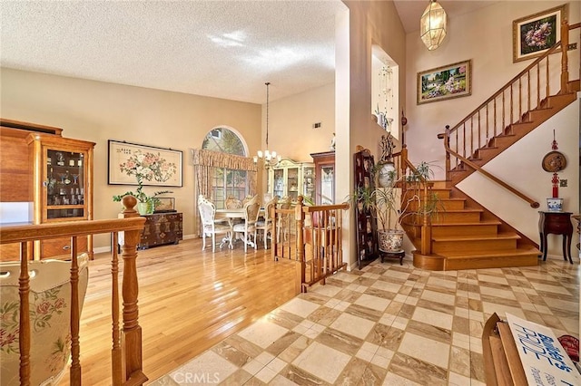 1135 Summitridge Dr, Diamond Bar, CA 91765 - entrance foyer with stairs, a notable chandelier, wood finished floors, and a textured ceiling