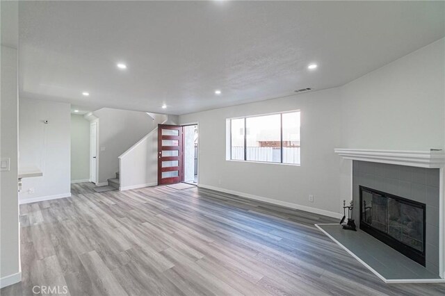4706 W 168th St, Lawndale, CA 90260 - unfurnished living room featuring a glass covered fireplace, wood finished floors, stairway, and recessed lighting