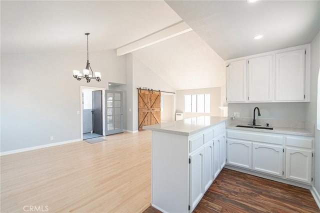 4706 W 168th St, Lawndale, CA 90260 - kitchen with a barn door, a peninsula, white cabinetry, wood finished floors, and light countertops