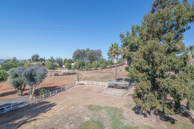 view of yard featuring a rural view, fence, and an enclosed area