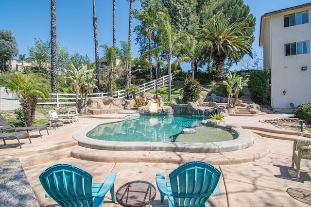view of swimming pool with a patio area and fence