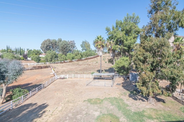 view of yard with fence, an enclosed area, and a rural view