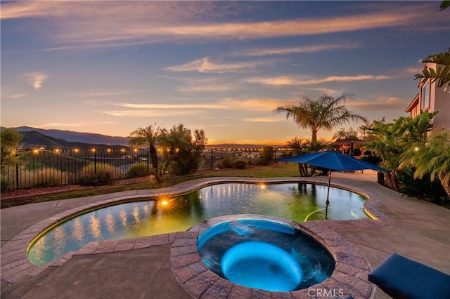 16720 S Peak Ct, Riverside, CA 92503 - pool at dusk with a pool with connected hot tub, a mountain view, and a patio