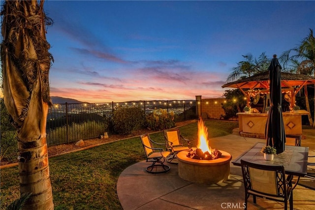 16720 S Peak Ct, Riverside, CA 92503 - patio terrace at dusk with a fire pit, a patio, and a fenced backyard