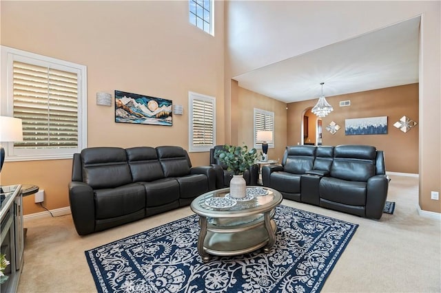 16720 S Peak Ct, Riverside, CA 92503 - living room with carpet, a chandelier, arched walkways, and a towering ceiling