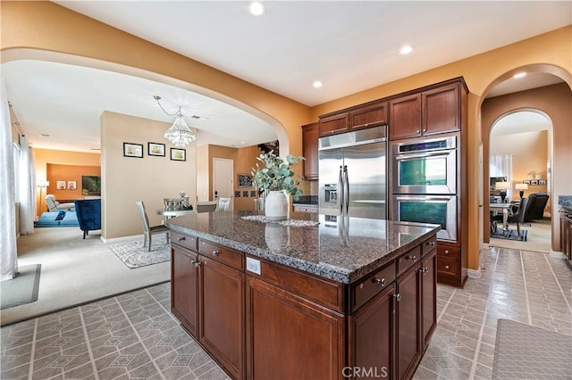 16720 S Peak Ct, Riverside, CA 92503 - kitchen with stainless steel appliances, light colored carpet, a center island, arched walkways, and recessed lighting