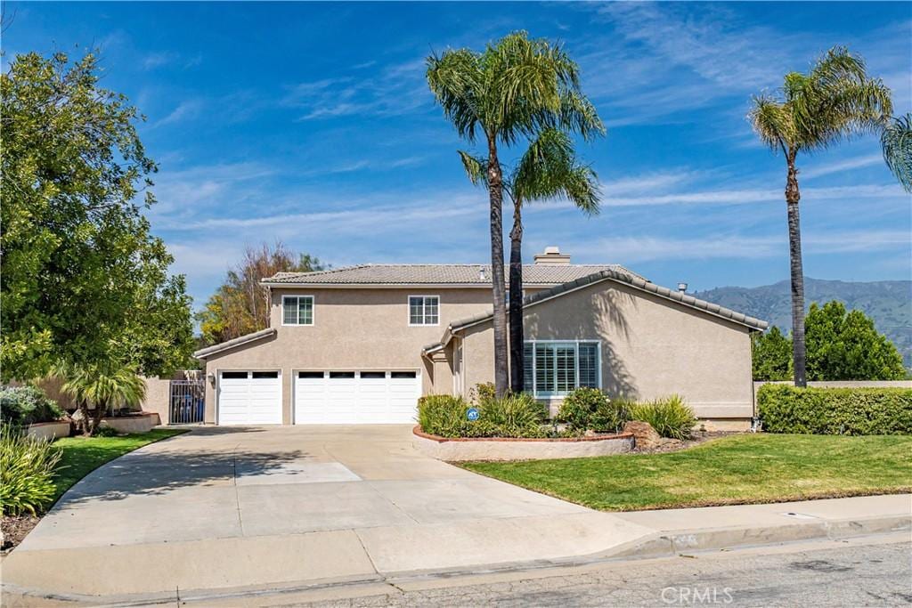 1569 Canyon Meadows Ln, Glendora, CA 91740 - view of front facade featuring driveway, a tile roof, a chimney, stucco siding, and an attached garage