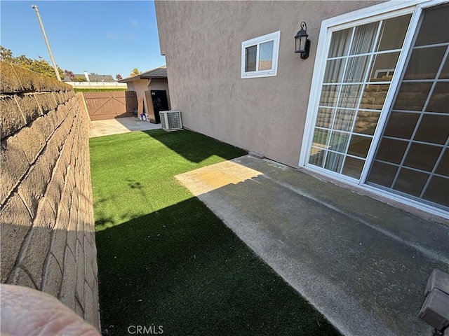 view of yard with cooling unit, a fenced backyard, and a patio area