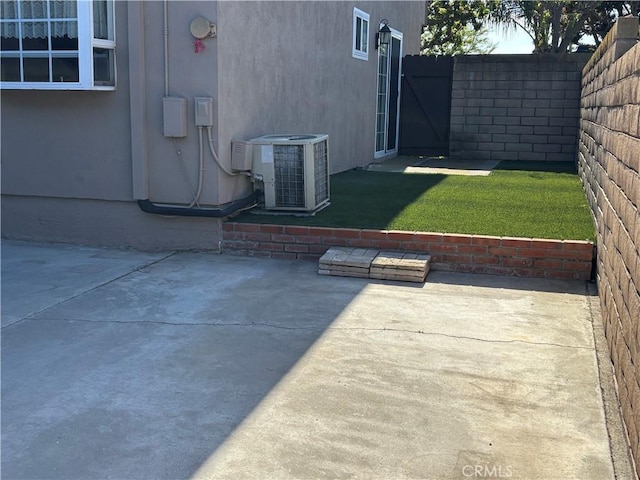 view of yard with central AC, a fenced backyard, and a patio area